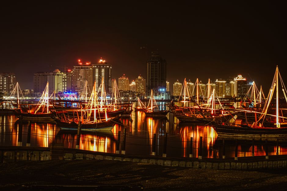 Illuminated traditional dhows at night